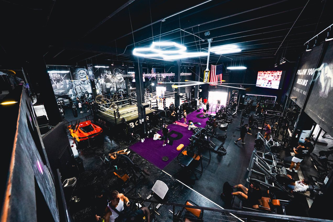 The BOXR main floor: rings, bags and the purple turf under the hex lights