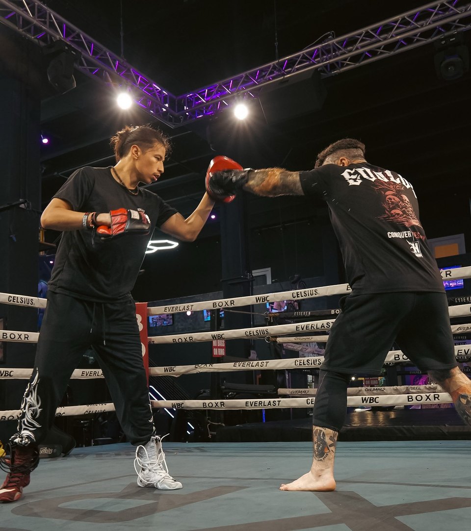 Mitt work in the BOXR ring under purple truss lights and spotlights.