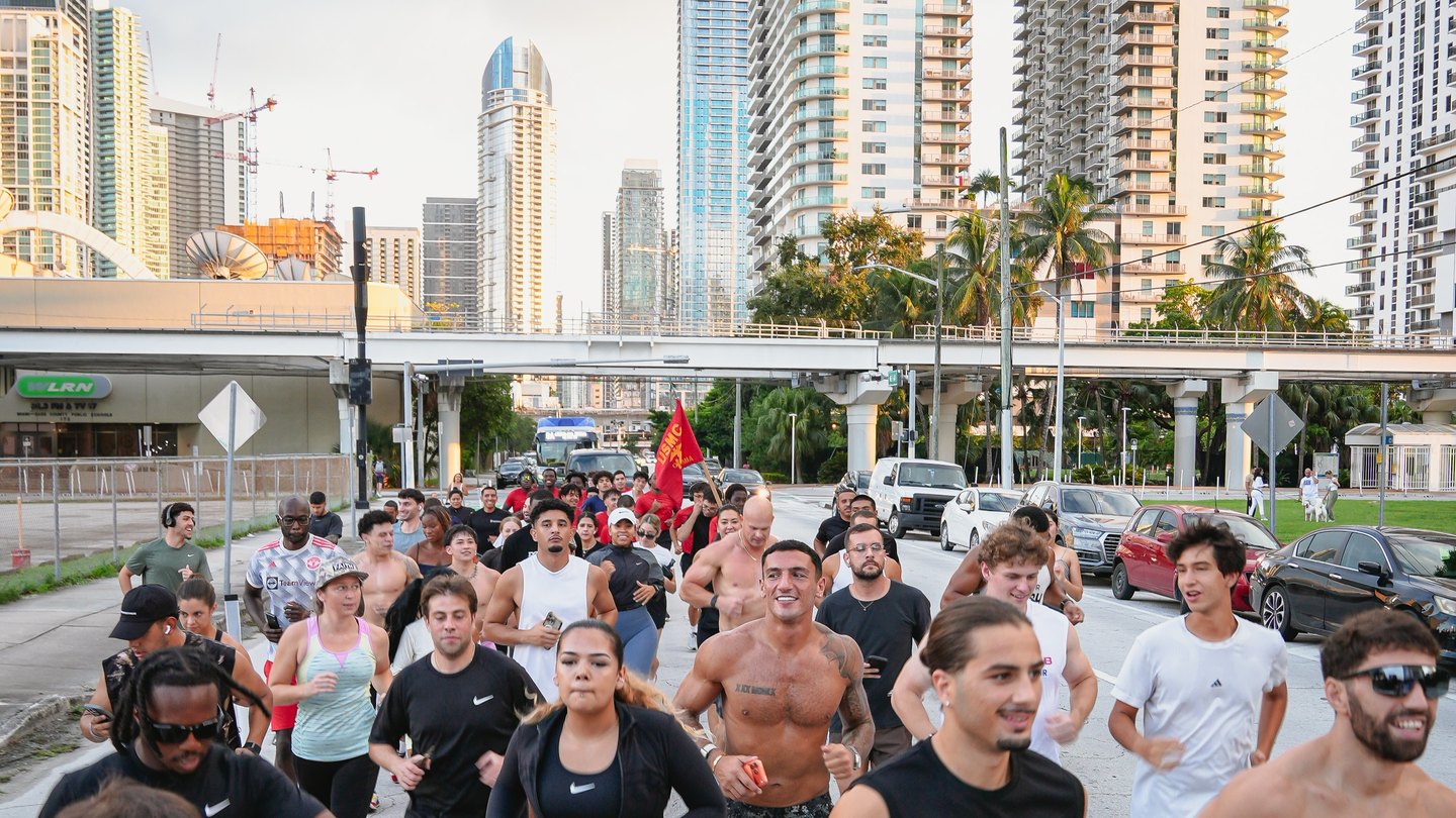 The BOXR Run Club on a Downtown Miami street at golden hour, towers and the Metromover behind