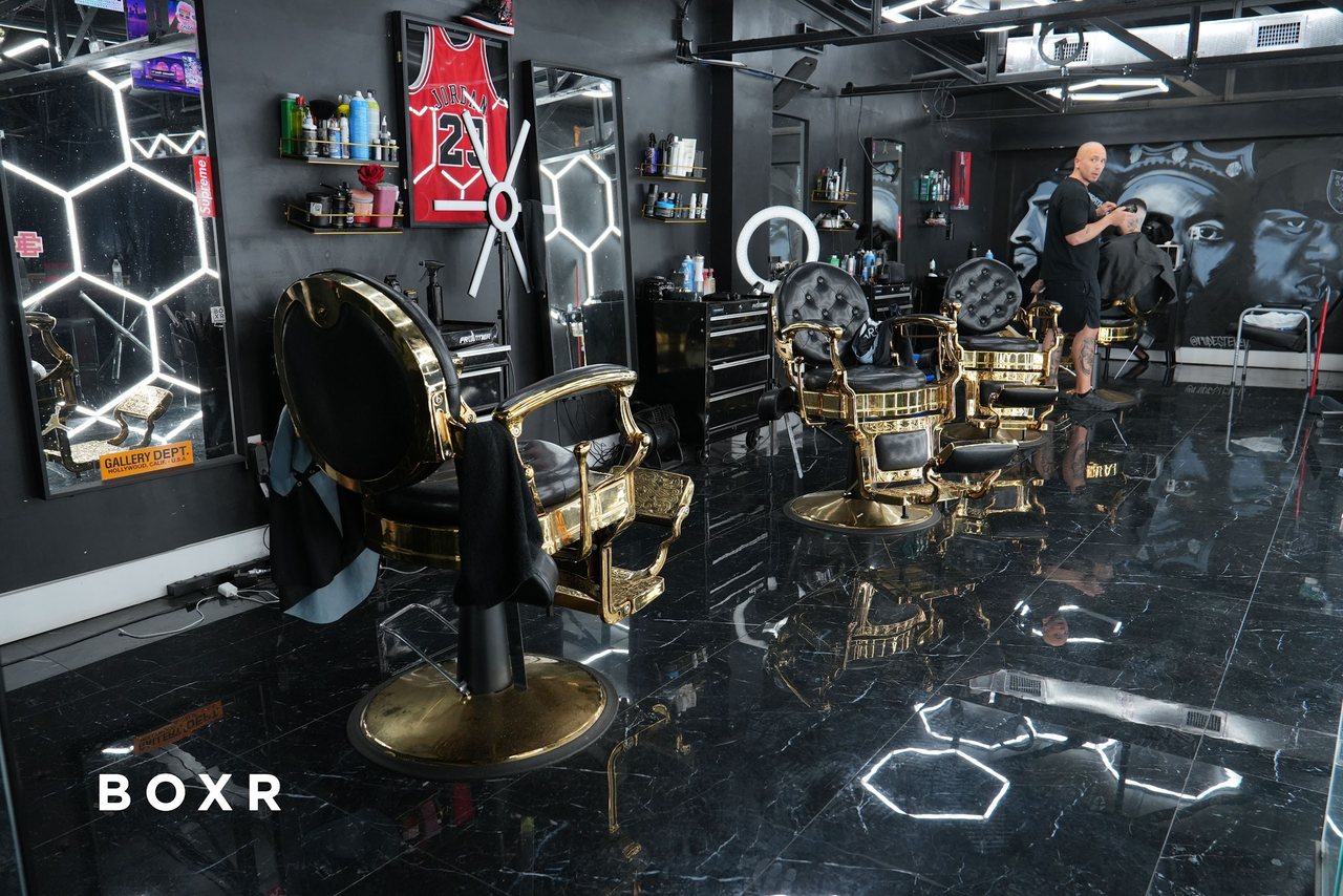 The BOXR barbershop: gold barber chairs under hex lights