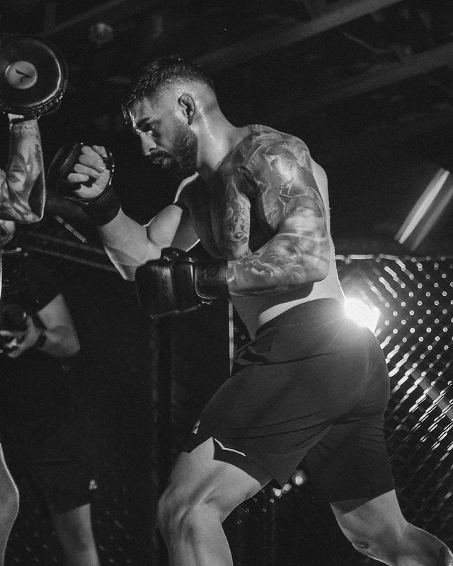 Ilia Topuria working the mitts, in black and white.